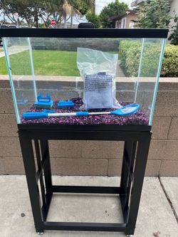rectangular glass aquarium, a metal aquarium stand, pink and black substrate gravel,