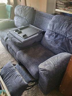Blue reclining couch features a center console with built-in cup holders and a drop-down table for storage and convenience (right-side recliner not wo