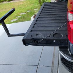 Hitch-mounted truck bed extender, "Extend-A-Truck". 
Extends truck bed cargo capacity by approximately 4 feet, ideal for hauling ladders, kayaks, lumb