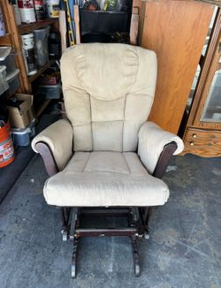 Dutailier  wooden nursery glider rocker chair featuring a dark espresso wood frame paired with plush beige/cream microfiber cushions.