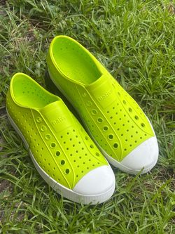 Lightweight Native Jefferson shoes are size Men's 7 and Women's 9. These lime green slip-ons have an EVA upper and sole with a white rubber toe cap. T