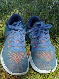 Blue Nike Free RN running shoes are women's size 10. The shoes have a mesh upper with orange accents and white soles. Preowned in good condition Pet