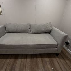 Living Spaces Grey Couch With Two Pillows