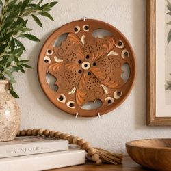 Beautiful 9-inch terracotta wall plate featuring an intricate openwork floral design with carved and hand-painted details in warm earthy terracotta, p