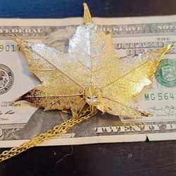 24k Gold, Real Maple Leaf Coated in Gold. Brand new, never worn. Comes with a 24-in chain.