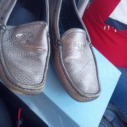 This is a pair of metallic silver Prada leather driving moccasins.
