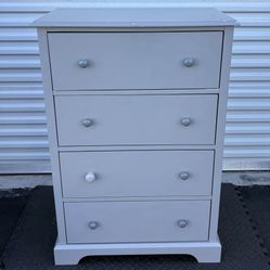 42”x29” four-drawer chest of drawers with a light gray painted finish and simple, round knobs.