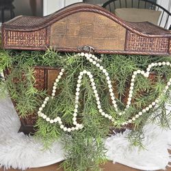 Antique wooden chest with artificial plant and pearls spilling out