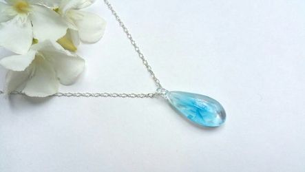 Necklace with handblown glass teardrop pendant with painted blue flower on a silver colored chain