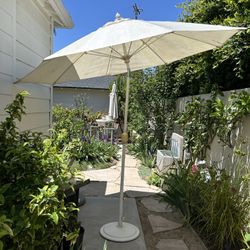 Tilting Umbrella with White Cast Iron Base and Cover.