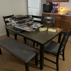 Kitchen table with four chairs and a bench