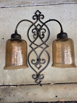 two-light rustic or Spanish-style metal wall sconce with a dark bronze or iron finish