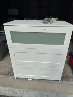 chest of 3 drawers which is distinguished by its white finish and frosted glass top drawer
