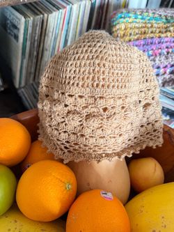 Handmade beige crochet bucket hat featuring a textured bobble stitch band and a scalloped picot edge brim.