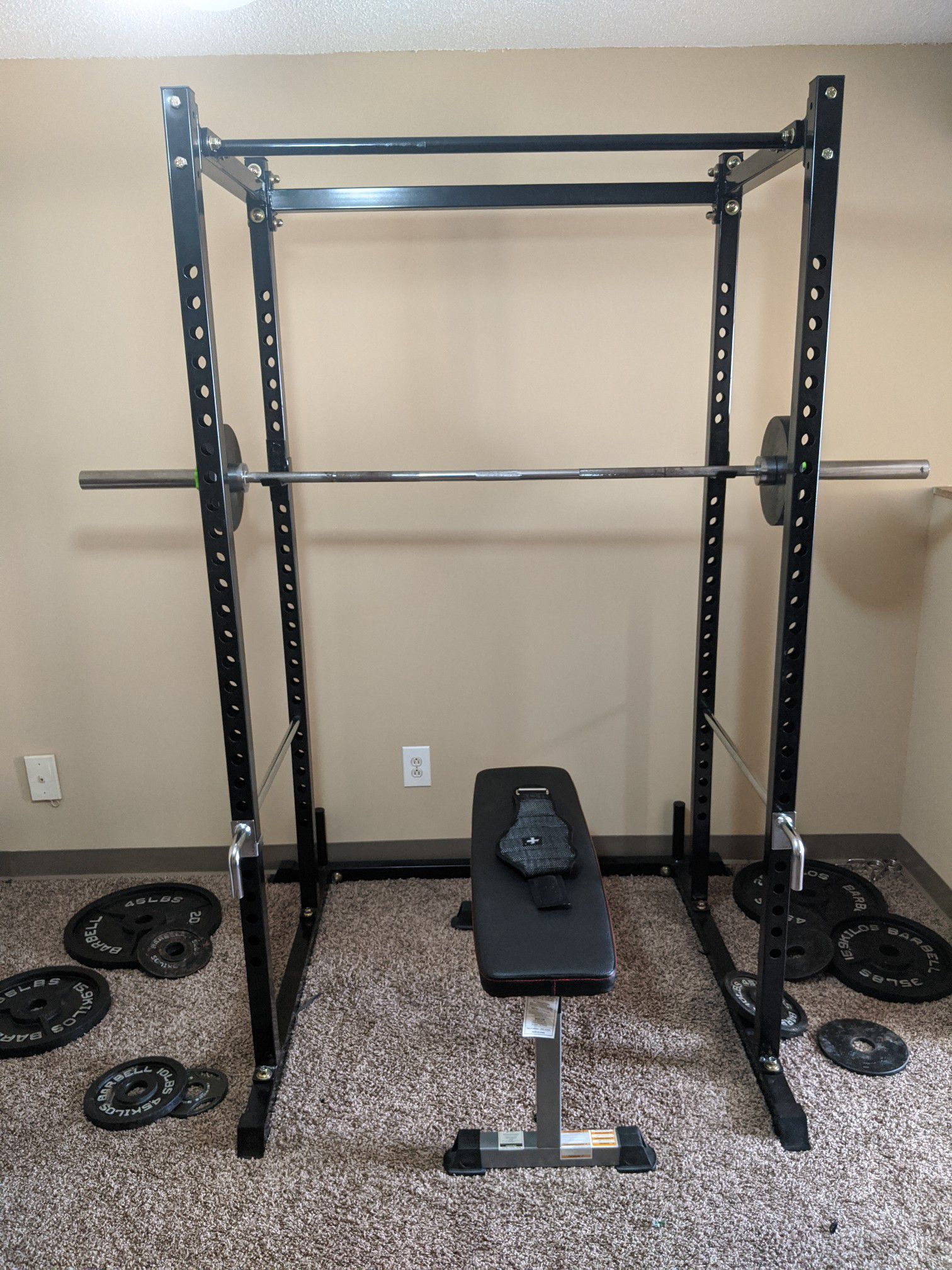 Squat rack with bench, weights, barbell and belt