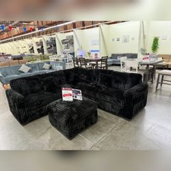 Black jumbo corduroy sectional sofa with ottoman