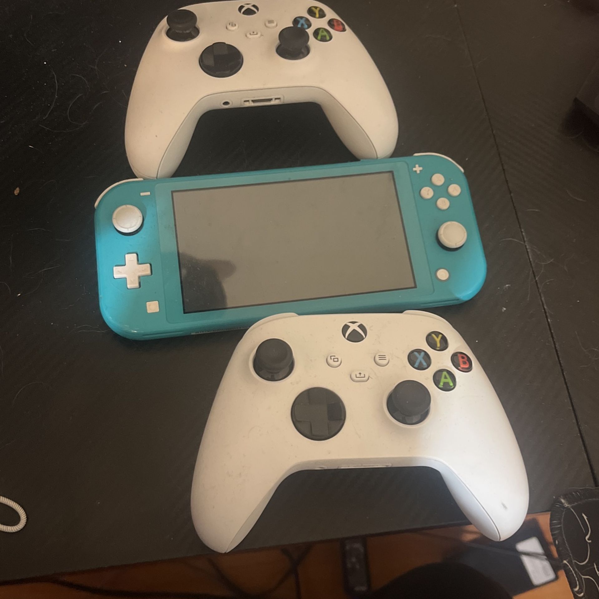 Nintendo Switch And Two Xbox Controllers
