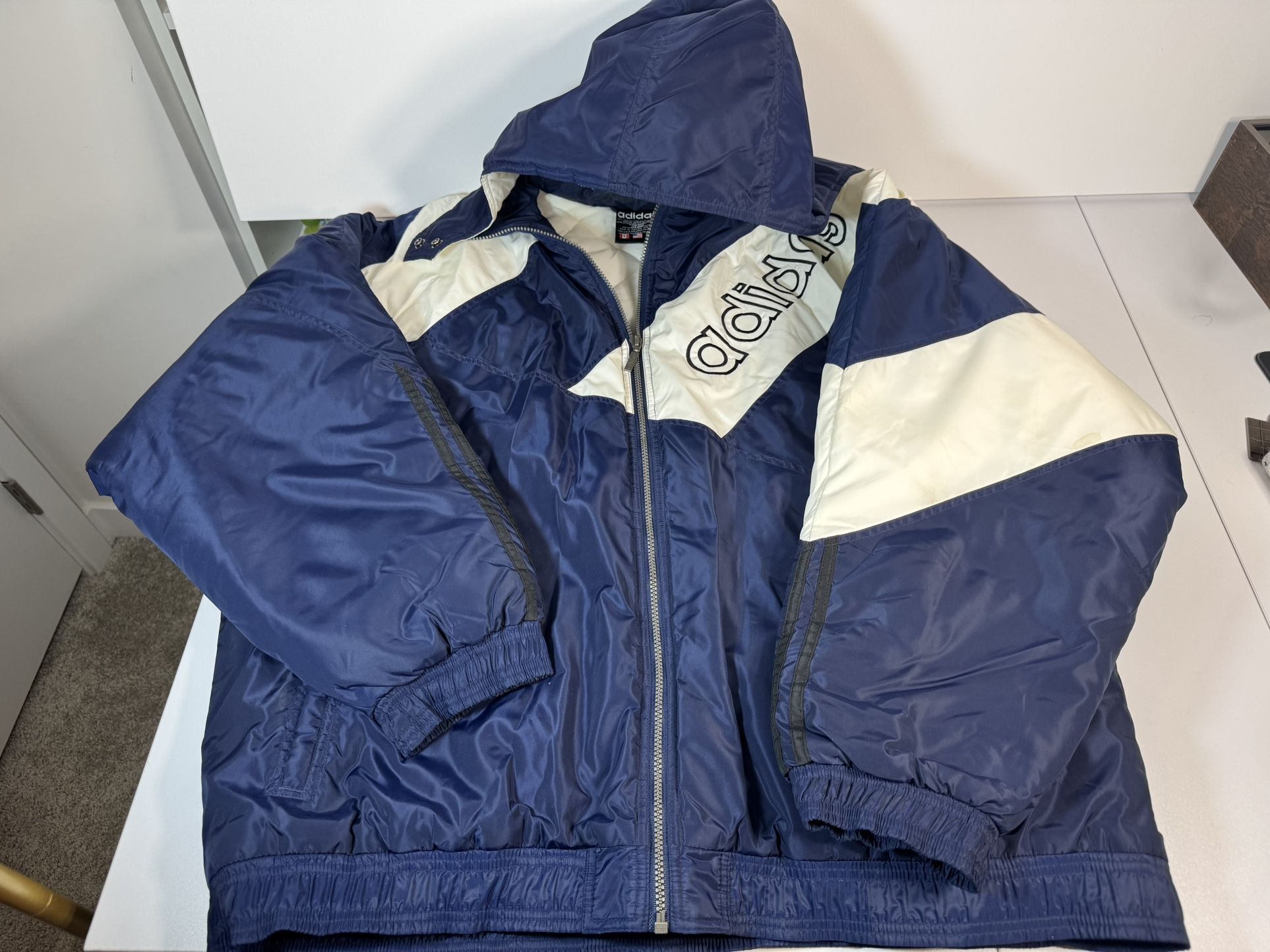 Vintage Adidas puffer jacket in deep navy with cream paneling and bold embroidered branding. Size XXL