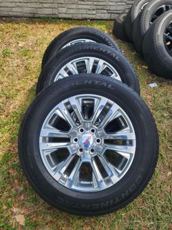 20-inch OEM polished aluminum wheels for a GMC Sierra or Yukon.