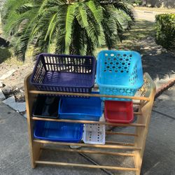 kids' toy storage organizer with a wooden frame and multi-colored plastic bins. 