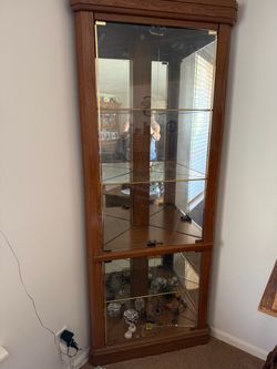 Nice wood corner cabinet with glass shelves and mirrored back