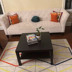 Elegant white tufted sofa with colorful cushions.