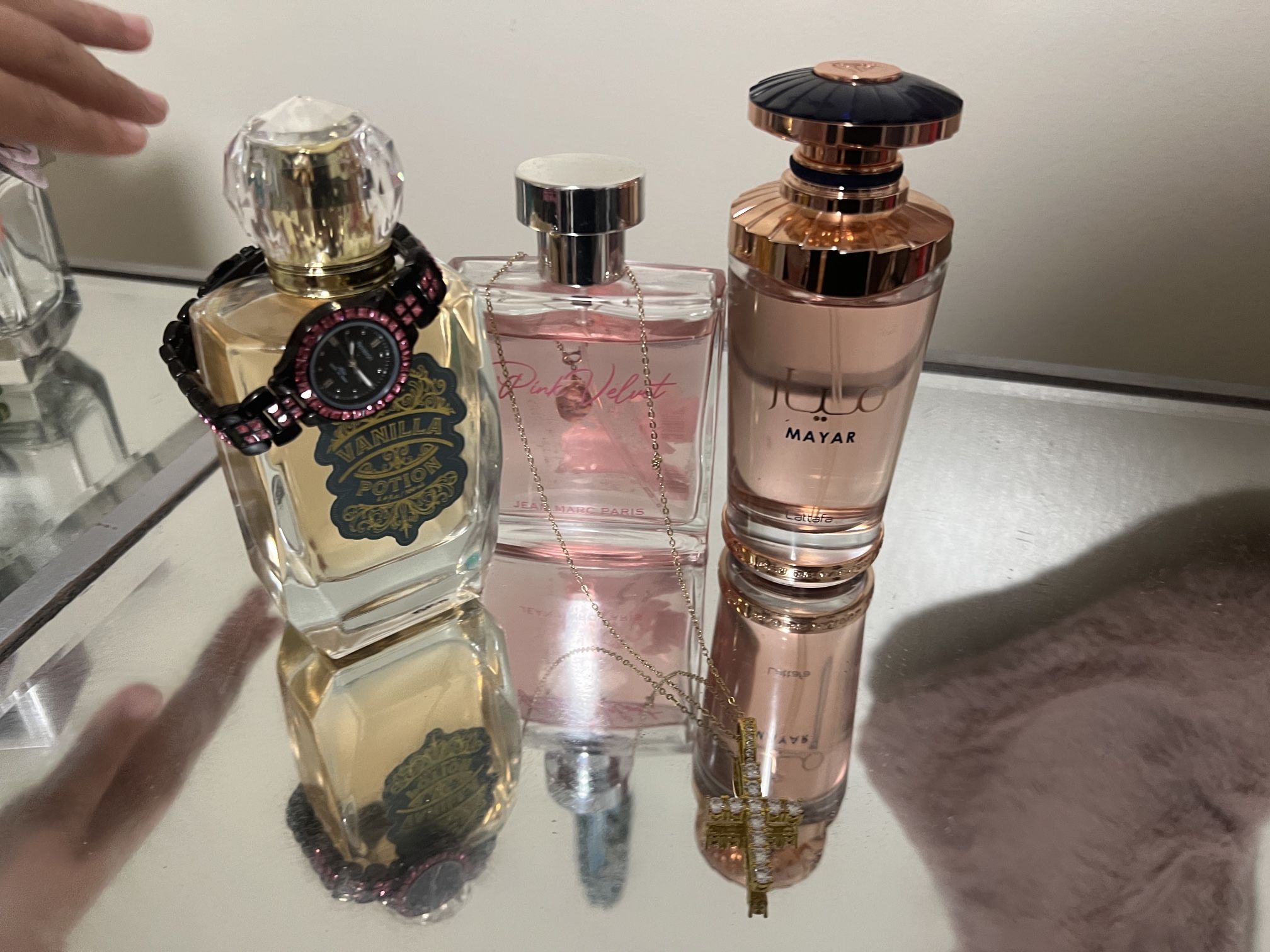 3 really cute perfumes with a watch and a cross