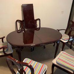 Paragon Co Dark Brown Gloss Wood Dining Table with Chairs and extra leaf  The table top has an oval shape and consists of two parts. The two halves of