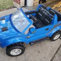 Battery-powered ride-on Power Wheels Ford F-150 Raptor ride-on truck. 
 