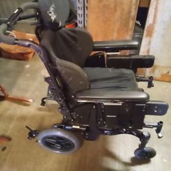 Wheelchair w/ leg supporters and head support.