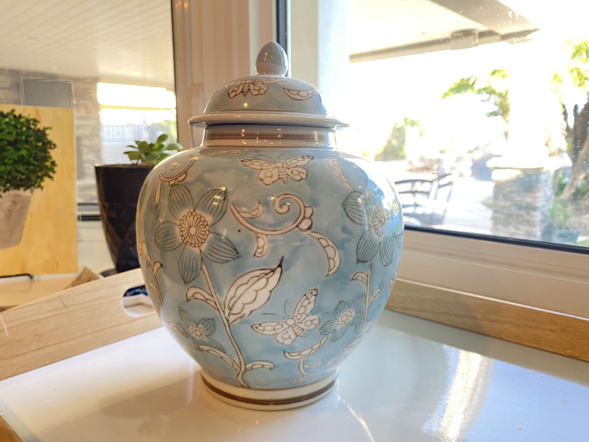 Light blue decorative jar with white flowers