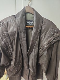 This is a vintage 1980s chocolate brown genuine leather oversized bomber jacket.