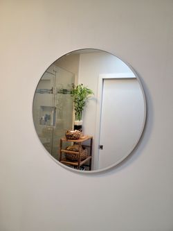 Circular wall mirror with a slim white metal frame, ideal for bathrooms, entryways, or living rooms. Minimalist frame that complements modern décor. D