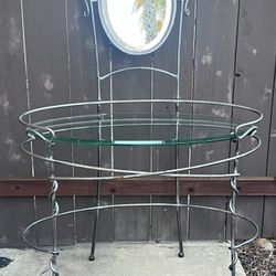  iron vanity table with a glass top and an attached oval mirror
