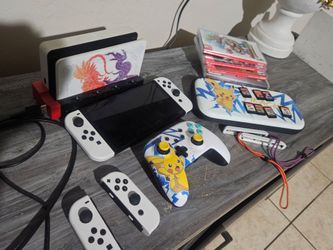 Switch Oled with 1TB memory, 4 joycons, Games, Case, Cables, wired controller, and charging station.