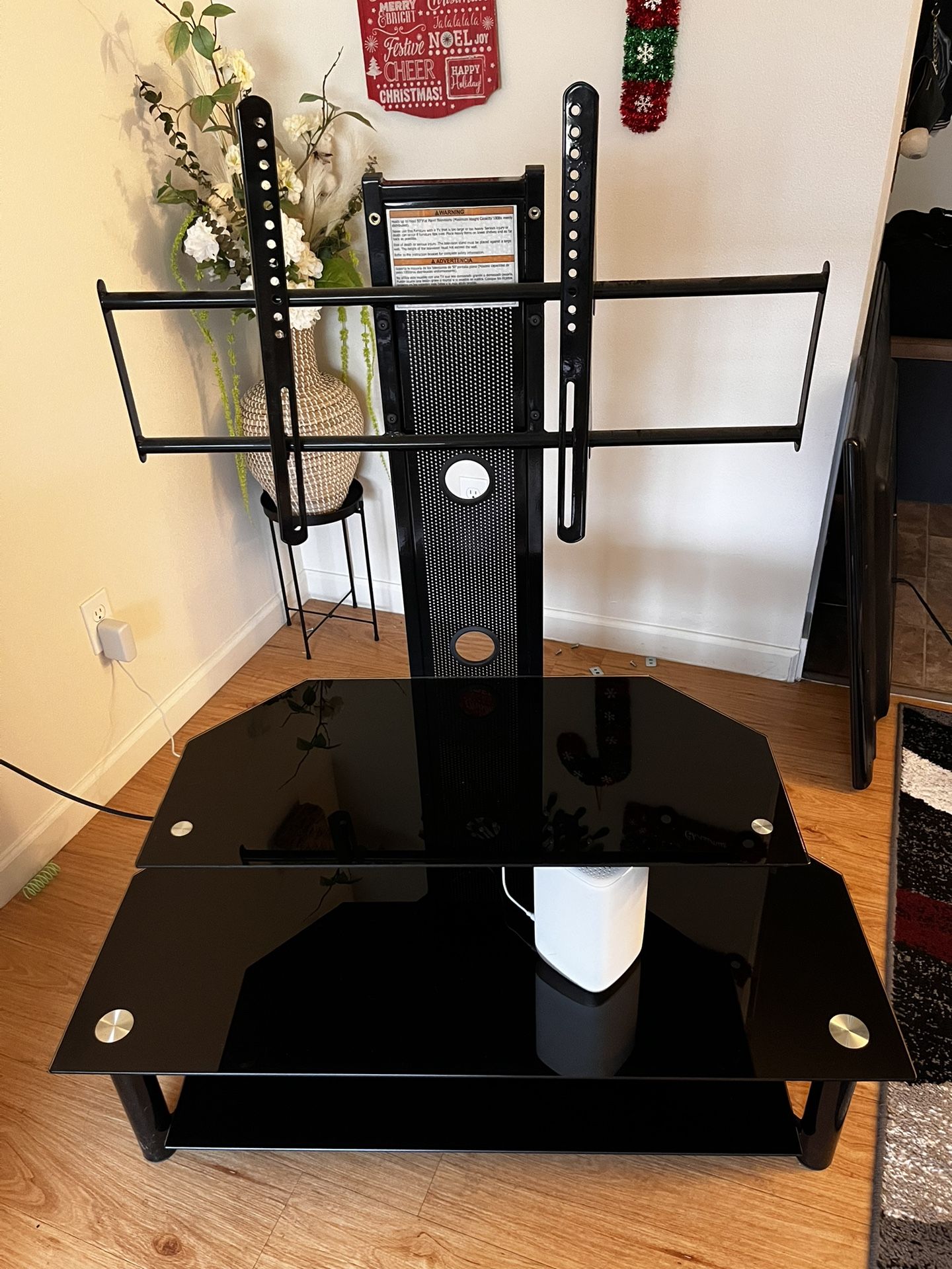 Nice 3 Tier Black Tempered Glass TV Stand with Adjustable TV Mount.  Holding a 55” Tv in pictures.  Great Like New Condition. No Scratches or Cracks. 