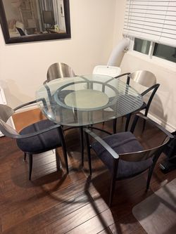 Mid-century glass kitchen table with four black chairs