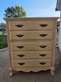 Solid wood 5-drawer chest by Fairmont Designs 

(sold new for $1,679). 

Cream/oyster finish, ornate black pulls, carved feet, dovetail drawers that s