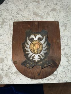vintage wall plaque features a medieval-style knight shield with a double-headed eagle crest and a damascene-style medal