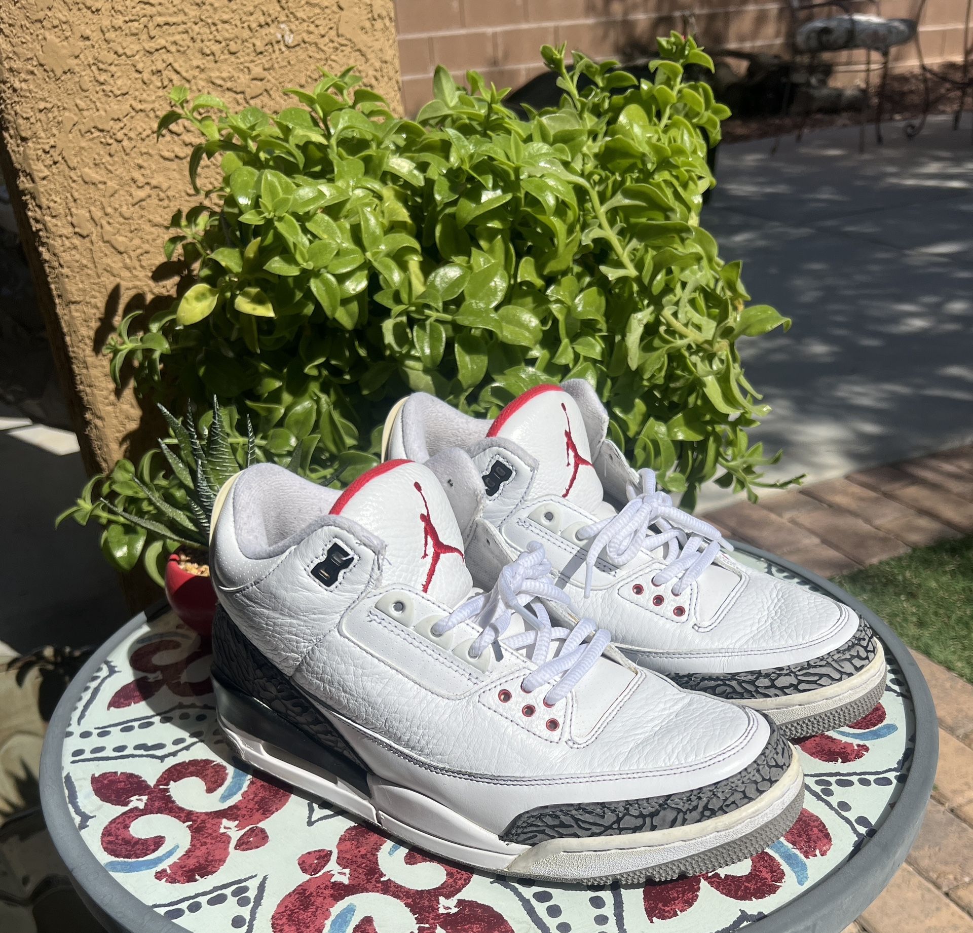 The product is a pair of men's Size 9 Jordan 3 Retro White Cement sneakers from 2011. These athletic shoes feature a low top silhouette and a classic