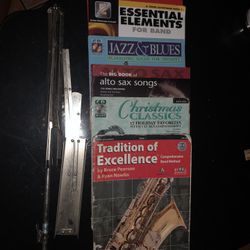 6 music books 3 for alto sax, 2 for tenor sax, and 1 for trumpet with a music stand