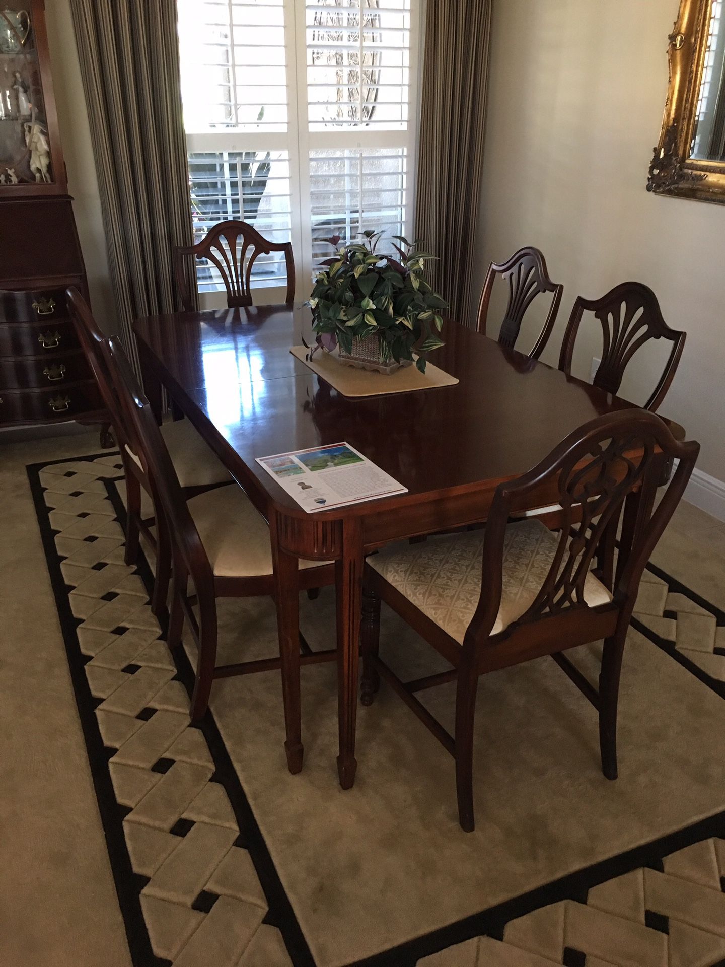 Duncan Phyfe style dining room table and 6 chairs. Includes one leaf and protective cover. Seats need recovering.
