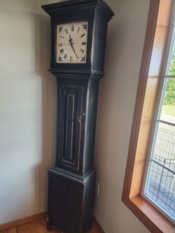 Tall black wooden clock with cabinet