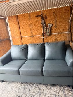 Ashley Genoa Steel sofa features a gray leather match finish and flared arms.