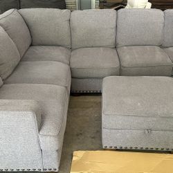 Thomasville Emilee Fabric Sectional with Storage Ottoman  Floor model, still in great condition.  Features: Color: Gray 100% Polyester Fabric Sinuous 