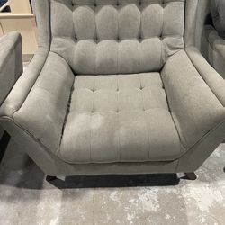 Two oversized light grey chairs and a loveseat