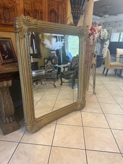 Elegant gold-framed mirror with intricate detailing living room, dining room entranceway mirror
