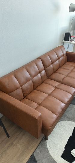 Tufted faux-leather/brown sofa.