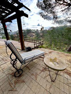 Black rod iron lounge chair with wheels and cushion