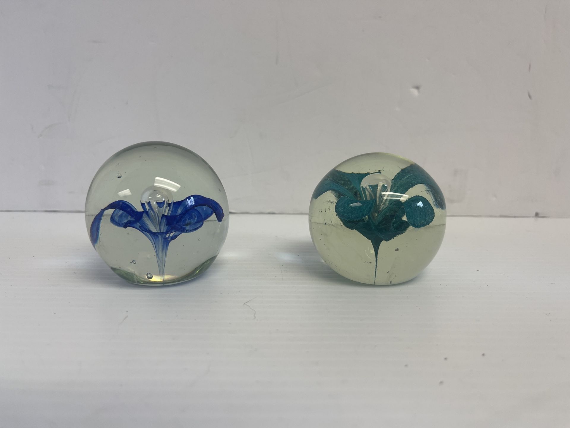 2 round blown glass flower paper weights 1 blue 1 green flower - D1010  This beautiful set of two round paper weights features delicate floral pattern